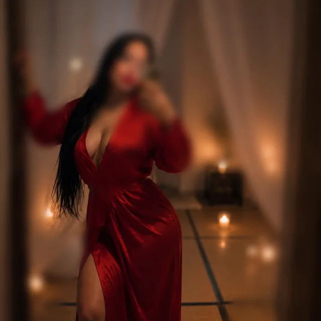 Terapeuta de Club de Señores con vestido rojo en un ambiente íntimo y cálido